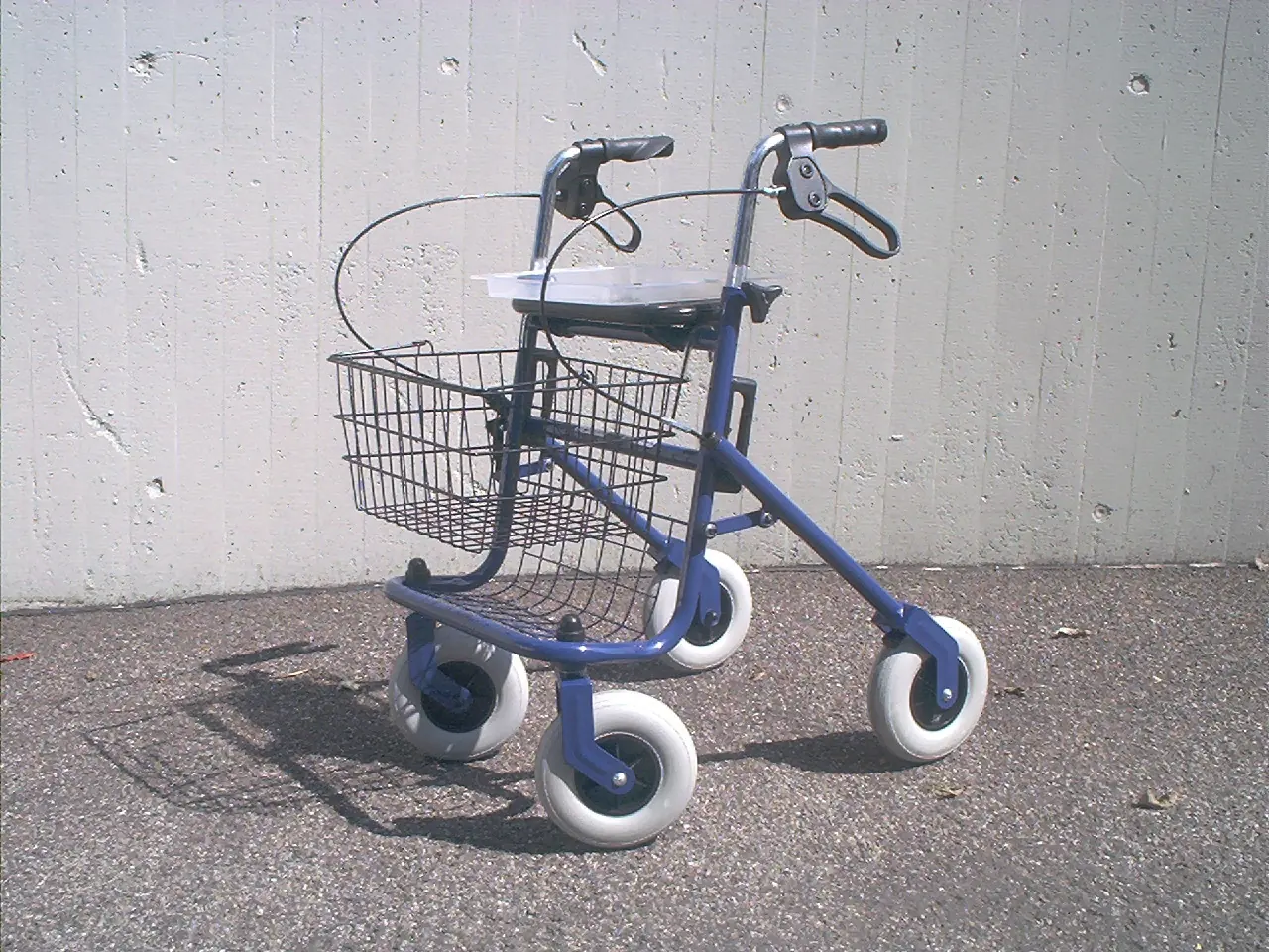 A blue four-wheeled rollator with a wire basket and seat
